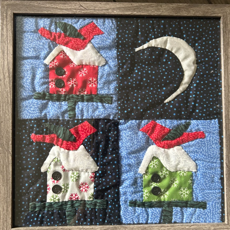 Framed four-panel Christmas birdhouse quilted wall art with red, green and white snowflake fabric on starry night background