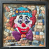 Framed quilted clown portrait wall art with teal hat, red hair, purple bow tie and patchwork background in black frame