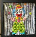 Framed quilted juggling clown wall art with green checkered overalls, blue hair, striped hat and colorful polka dots on black and white striped background