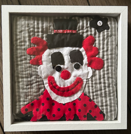 Bold quilted clown portrait appliqué wall art with red hair and top hat in white shadow box frame